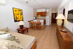 Habitación con cama y cocina con mesa en Costamar 13, en Es Pujols