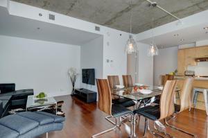 uma sala de jantar e sala de estar com mesa e cadeiras em Les Immeubles Charlevoix - Le 760506 em Cidade de Quebec