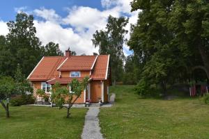 a house with a red roof in a yard at Cozy Country House in Spydeberg