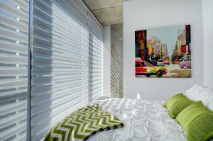 a bedroom with a bed and a window with blinds at Les Immeubles Charlevoix - Le 760-506 in Quebec City