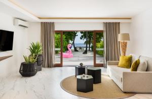 uma sala de estar com um sofá e um flamingo rosa em Kurumba Maldives em Malé