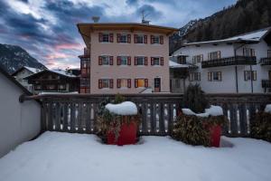 un grande edificio con neve sul balcone di Cesa te Piaz a Campitello di Fassa