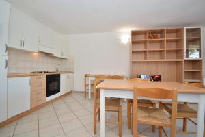 a kitchen with a table and chairs and a kitchen with white cabinets at Citai con splendida vista mare in San Teodoro