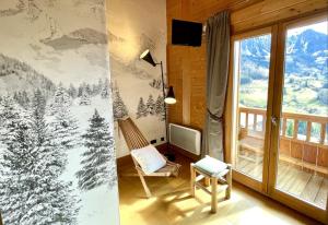 マニグードにあるChalet Alpaga Location de prestigeの椅子と雪に覆われた木々が並ぶ窓が備わる客室です。