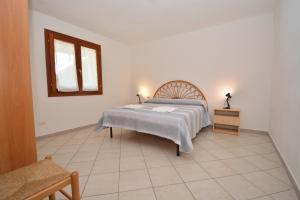 a bedroom with a bed and a table and a window at Citai con splendida vista mare in San Teodoro