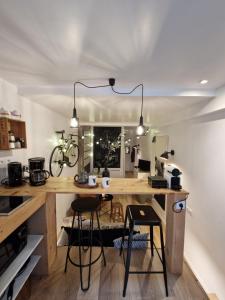 - une cuisine avec un bureau avec deux chaises et un vélo sur le mur dans l'établissement Baptiste le caviste, à Talence