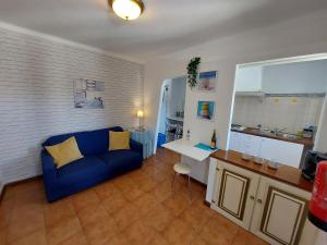 a living room with a blue couch and a desk at Hakuna matata in Benagil