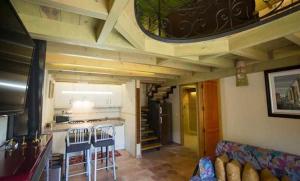 a room with a kitchen and a living room with a couch at Casa del Cerro es una singular casa rural de fácil acceso in Cabezas Bajas