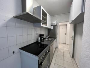 una piccola cucina con lavandino e piano cottura di OELTALAS Immobilien GmbH a Oldenburg