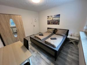 a small bedroom with a bed and a table at OELTALAS Immobilien GmbH in Oldenburg