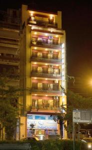 ein hohes Gebäude mit Balkon in der Nacht in der Unterkunft Pergamos Hotel in Athen