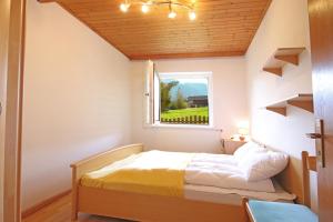 ein kleines Schlafzimmer mit einem Bett und einem Fenster in der Unterkunft Aurturist Dobbiaco Roulette in Toblach