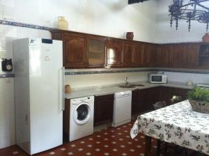 a kitchen with a refrigerator and a washing machine at Cortijo La Priorita in Córdoba