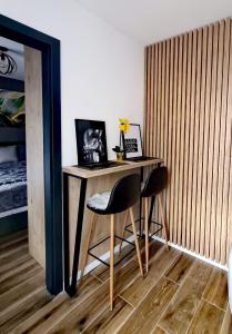 a desk with two chairs in a room with a bed at Apartman 12 - Jahorina in Jahorina