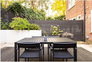 a black table with two chairs and a fence at Home Sweet Hampstead Heath in London