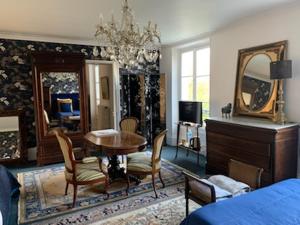 a living room with a table and chairs and a bedroom at Domaine de Ris in Ris-Orangis