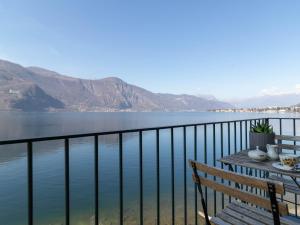 d'un balcon avec une table et une vue sur l'eau. dans l'établissement Mamma Ciccia Holiday Home - Sunset Balcony, à Abbadia Lariana