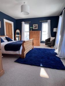 1 dormitorio con cama y pared azul en Field View, en Ashfield