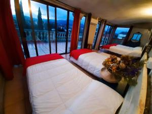 three beds in a room with a view of a balcony at Albergue Villa San Clemente in Tui