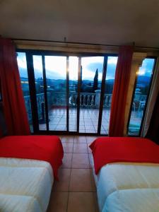 a room with two beds and a large window at Albergue Villa San Clemente in Tui