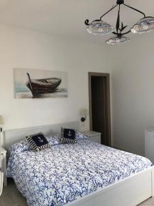a bedroom with a bed and a picture of a boat at Deluxe Lipari Room in Lipari