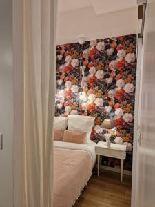 1 dormitorio con 1 cama con pared de flores en Alixe la styliste, en Talence