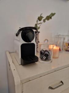 a coffee maker and a candle on a table at Alixe la styliste in Talence