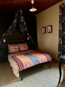 a bedroom with a bed with a canopy at La Passerelle in Loguivy-Plougras