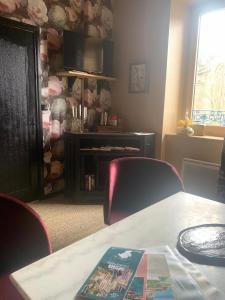 a room with a table and chairs with a book on it at La Passerelle in Loguivy-Plougras