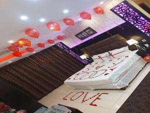 نزل السلطان للأجنجة الفندقية في جازان: غرفة بسرير وبالونات حمراء على الحائط