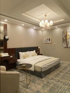 een hotelkamer met een bed en een kroonluchter bij الفخامه بارك in Şabyā