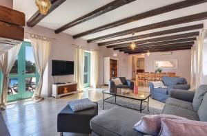 ein Wohnzimmer mit blauen Sofas und einem Fernseher in der Unterkunft Villa Lucia in Vodnjan