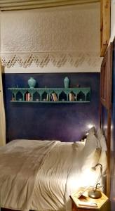 a bedroom with a bed and a shelf with vases at Les Bains de Fez Tara in Fez