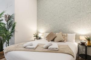 a bedroom with a large white bed with towels on it at BNBHolder Ponzano & Chamberi II in Madrid