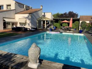 a swimming pool with a statue next to a house at Villa charmante à Nalliers avec piscine in Nalliers