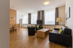 sala de estar con sofá, sillas y mesa en 3 Raum Ferienwohnung Premium, en Schulenberg im Oberharz