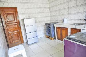 La cuisine est équipée d'un réfrigérateur et d'un lave-linge. dans l'établissement Three rooms Appartment Bieyem assi, à Yaoundé