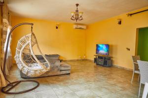 - un salon avec une balançoire et une télévision dans l'établissement Three rooms Appartment Bieyem assi, à Yaoundé
