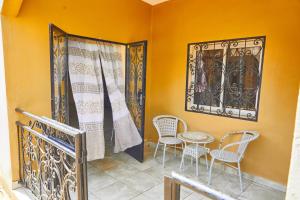 d'un balcon avec des chaises, une table et une fenêtre. dans l'établissement Three rooms Appartment Bieyem assi, à Yaoundé