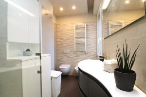 a bathroom with a toilet and a sink with a plant at Sant'Orsola Malpighi Apartment in Bologna +16 photos