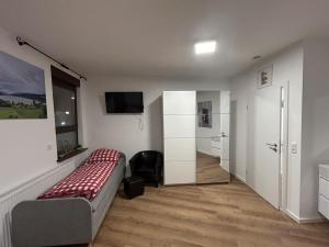 ein Schlafzimmer mit einem Bett und einem TV in der Unterkunft Aparthotel Waldhorn Wohnung Allgäustyle in Stuttgart