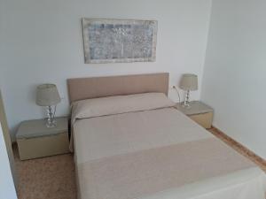 ein Schlafzimmer mit einem Bett mit zwei Nachttischen und zwei Lampen in der Unterkunft Suite familiar Portalet in Benaguacil