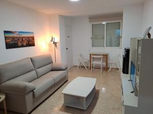 ein Wohnzimmer mit einem Sofa und einem Tisch in der Unterkunft Suite familiar Portalet in Benaguacil