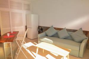 a living room with a couch and a table and a refrigerator at Apartamentos Playa Azul in Vallehermoso