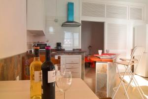 duas garrafas de vinho sentadas numa mesa numa cozinha em Apartamentos Playa Azul em Vallehermoso