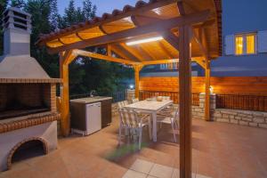 a patio with a table and a stove and a grill at Blue Villa 1 - With Private Pool in Perama
