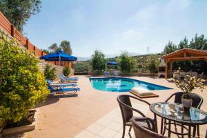 a patio with a table and chairs and a pool at Blue Villa 1 - With Private Pool in Perama