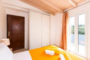 een slaapkamer met een bed en een groot raam bij Blue Villa 2 - With Private Pool in Perama