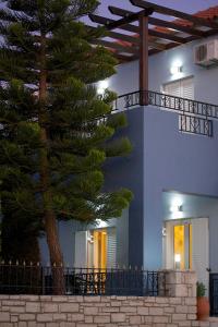 een huis met een dennenboom ervoor bij Blue Villa 2 - With Private Pool in Perama