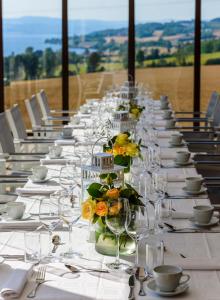 una mesa larga con copas de vino y flores. en Herregården Hoel - De Historiske en Nes i Ådal